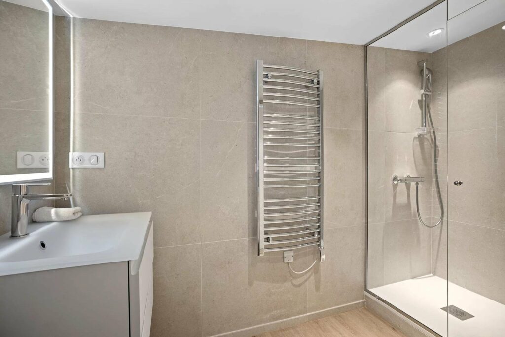 bathroom with beige tile walls and light wood floors