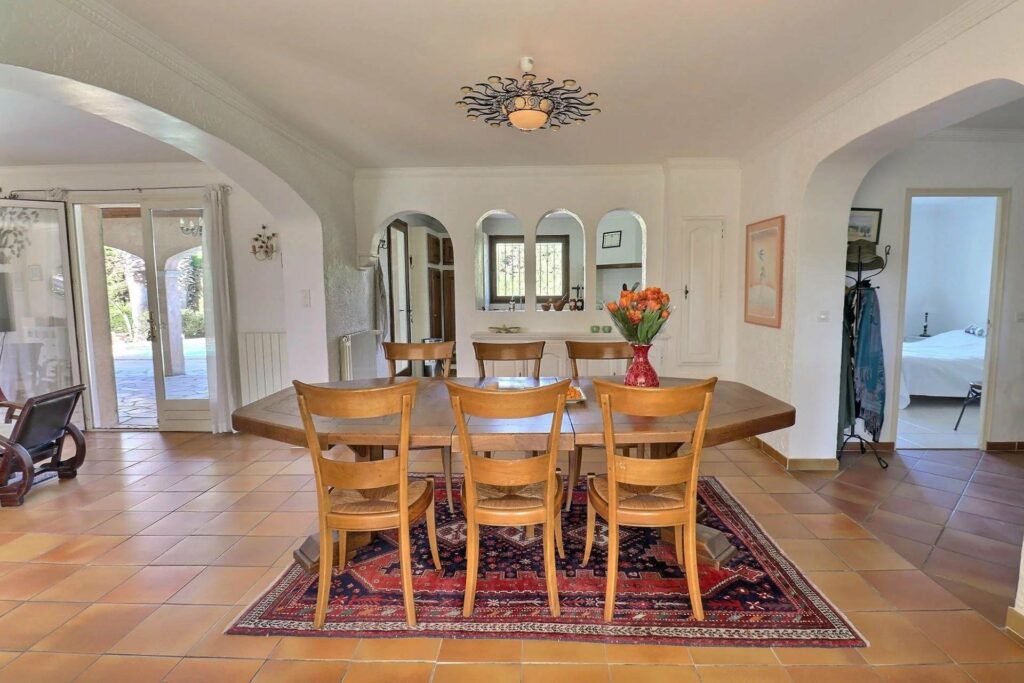 dining room with wooden round table above red printed rug