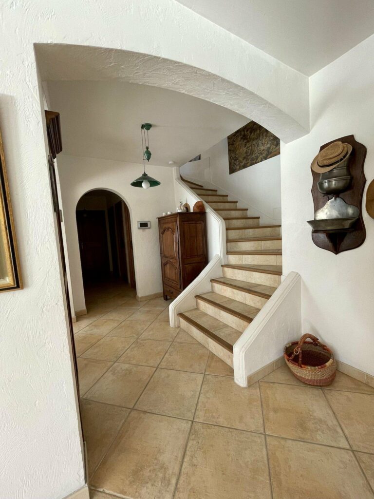 stairway with beige tile floors and white walls