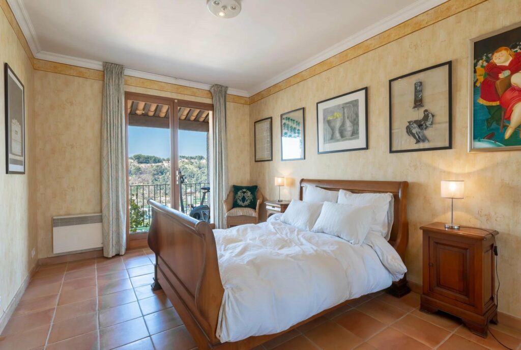 bedroom with queen size bed with white bedding and terracotta tile floors
