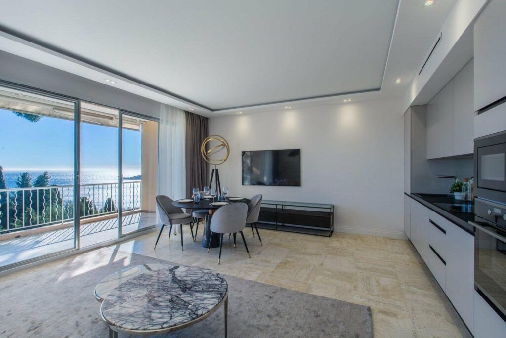 modern living room with beige tile floors and sliding glass door to terrace with sea view