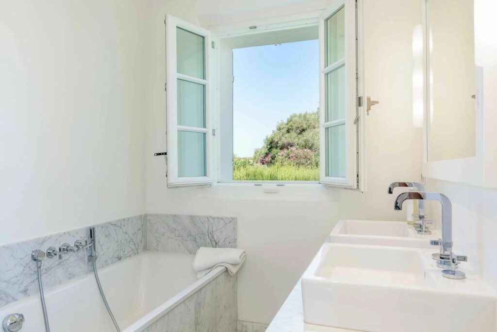 bathroom with grey marble bath tub and window with garden view