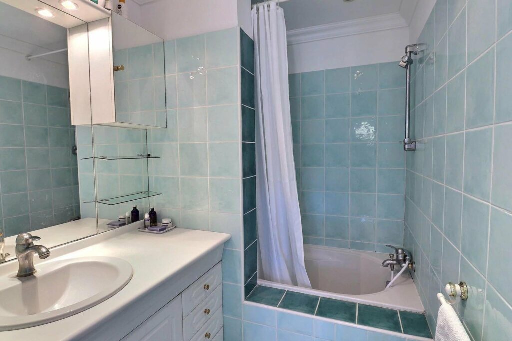bathroom with blue tile walls and white bath tub