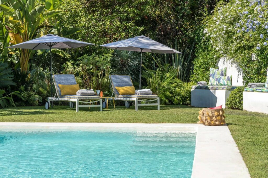 backyard with large swimming pool and blue and orange lounge chairs