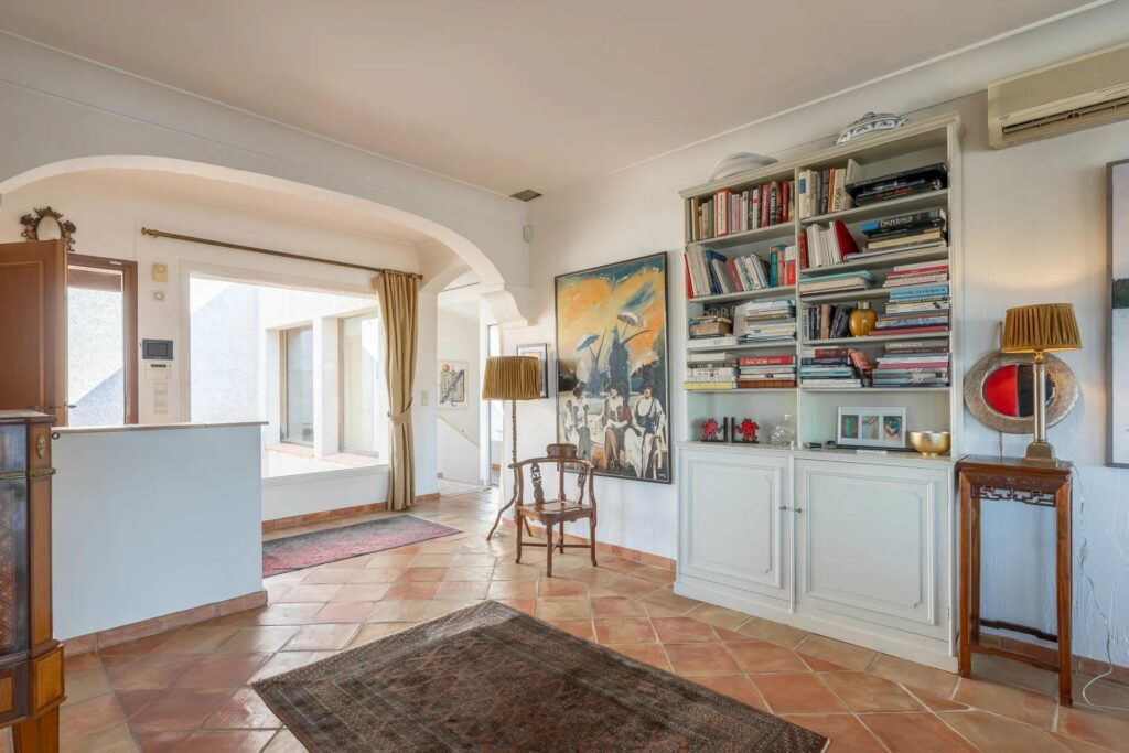 library of villa with terracotta tile floors and white shelves