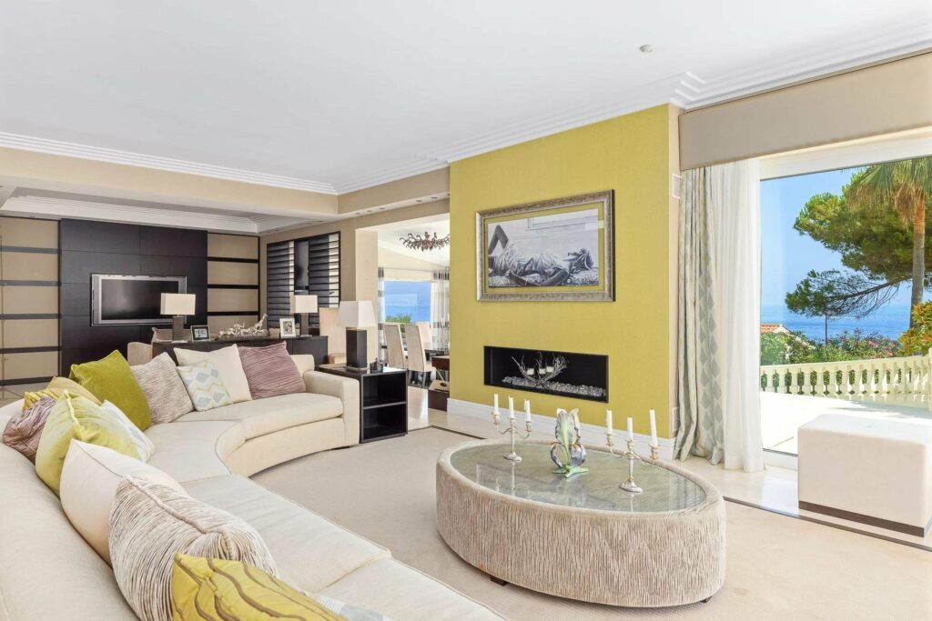 living room with yellow walls and L-shaped white couch