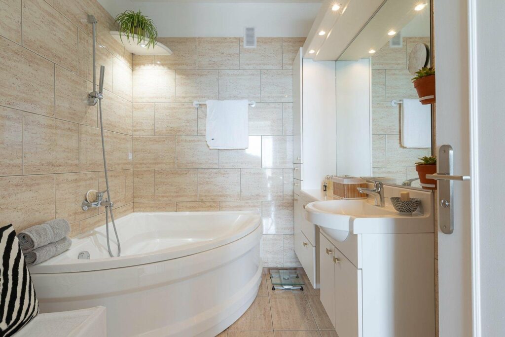 bathroom with bathtub and beige tiling