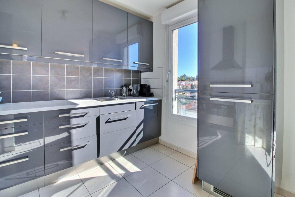 kitchen with grey cabinets and white tile floors with window with sea view