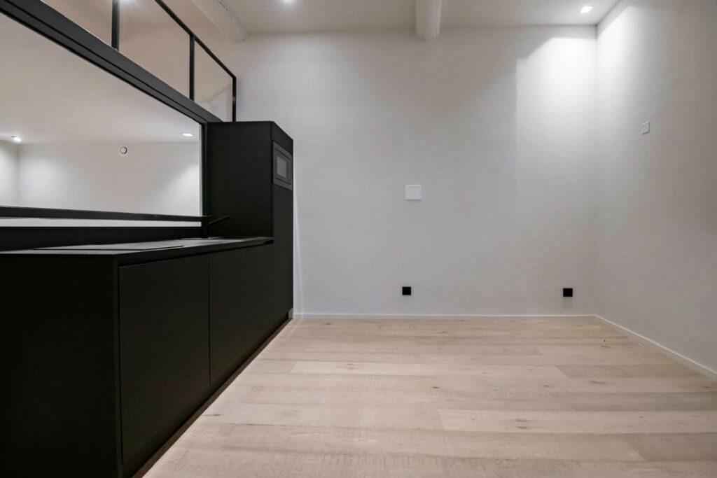 open studio apartment with mezzanine and matte black kitchen cabinets