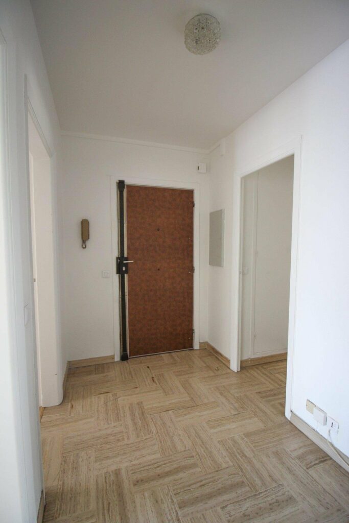 entrance with secured brown door and patterned wood floors