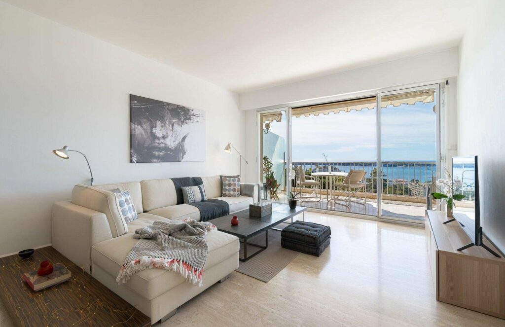 living room with beige tile floors and white couch with access to sea view terrace