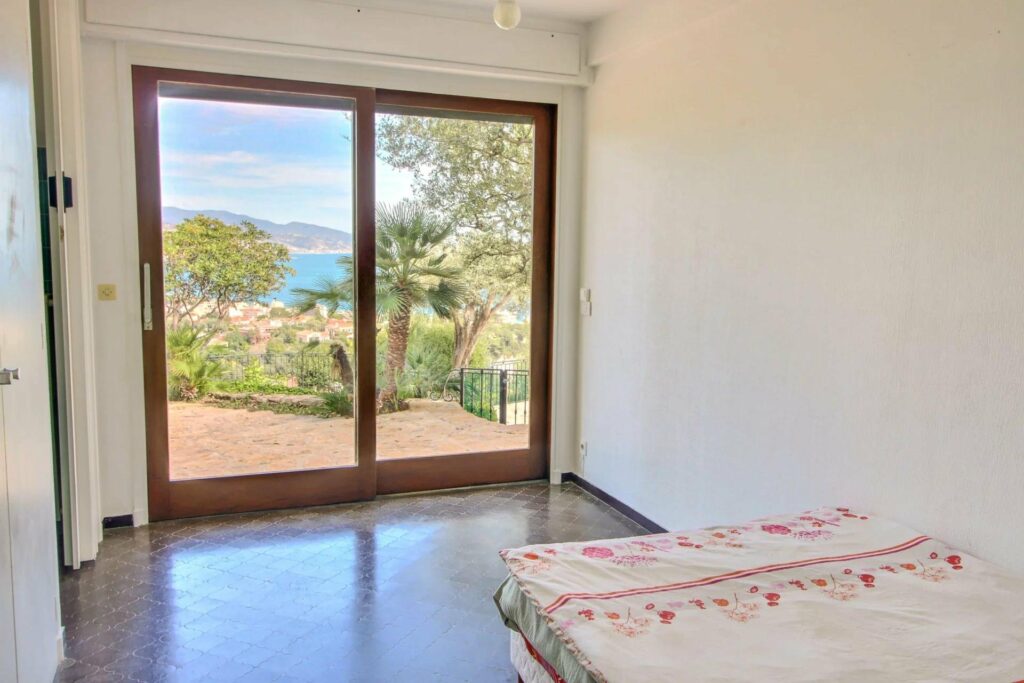 bedroom with large sliding glass door to terrace with sea view