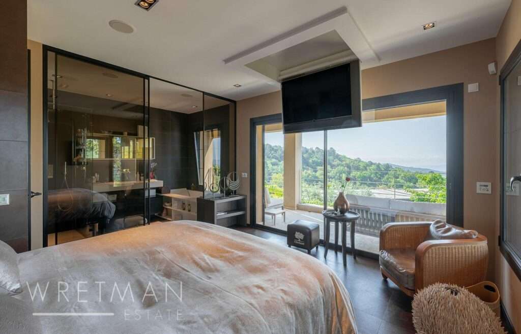 modern bedroom with floor to ceiling windows with view of the mountains