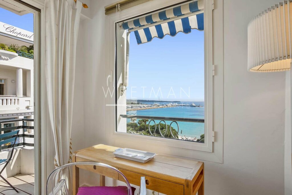 wooden table facing window with sea view