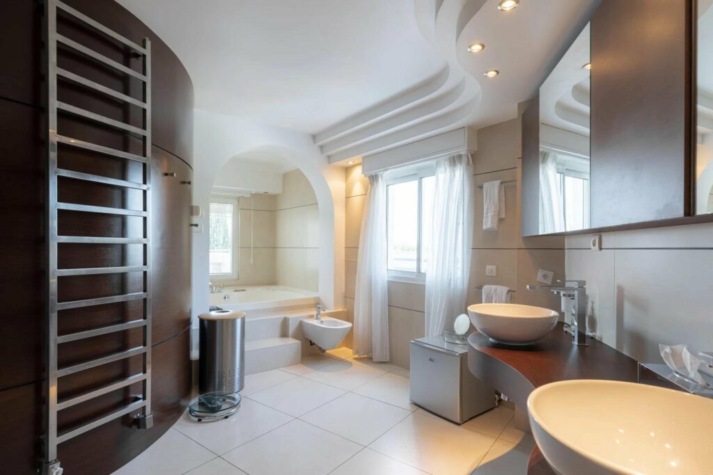 bathroom with beige tile floor and large bathtub