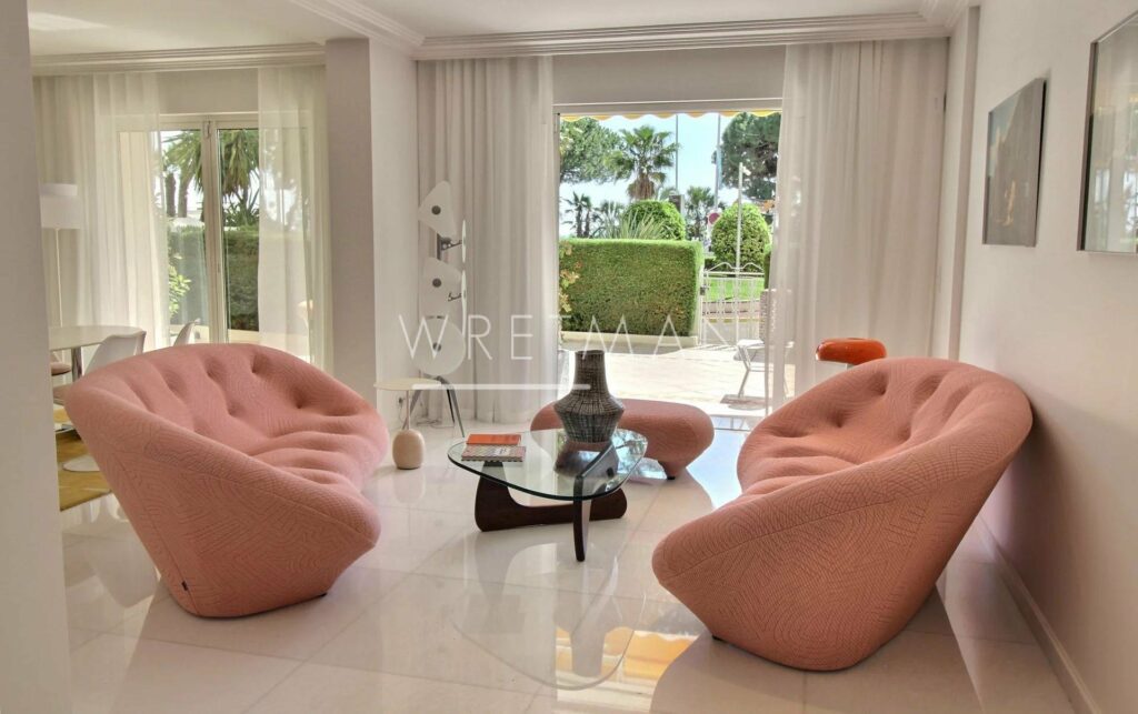 living room with two pink round couches facing each other and next to sliding glass door to garden