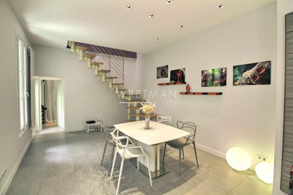 dining room with square white table and modern style staircase