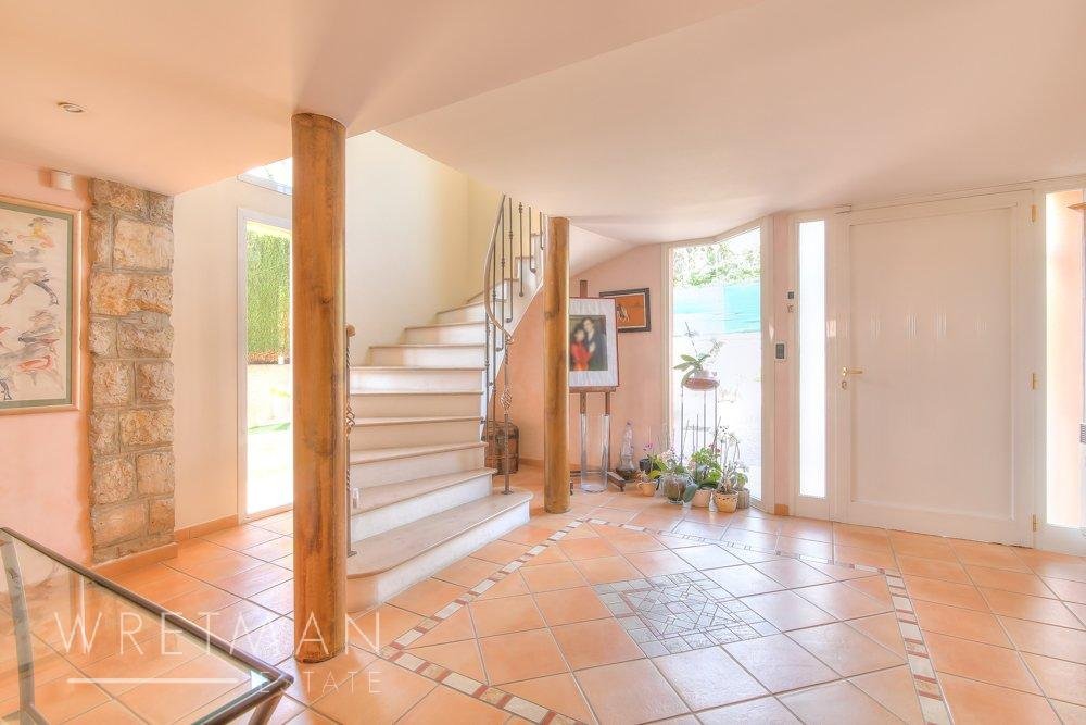 interior of villa with light orange tile floors and view of staircase leading upstairs