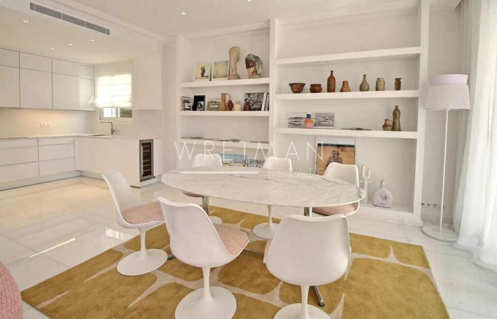 dining room with white round dining table and white shelves filled with colorful books