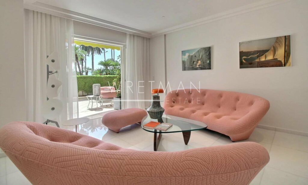 living room with light pink round couch and glass coffee table in center