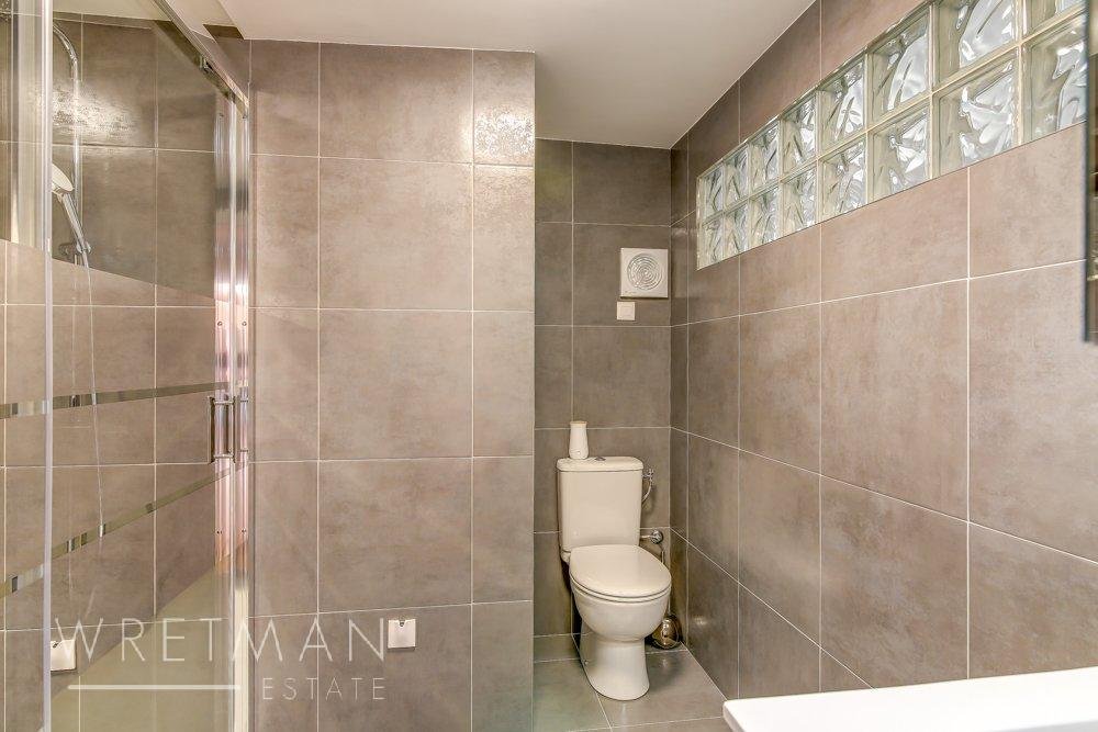 bathroom with grey tiling and large open shower