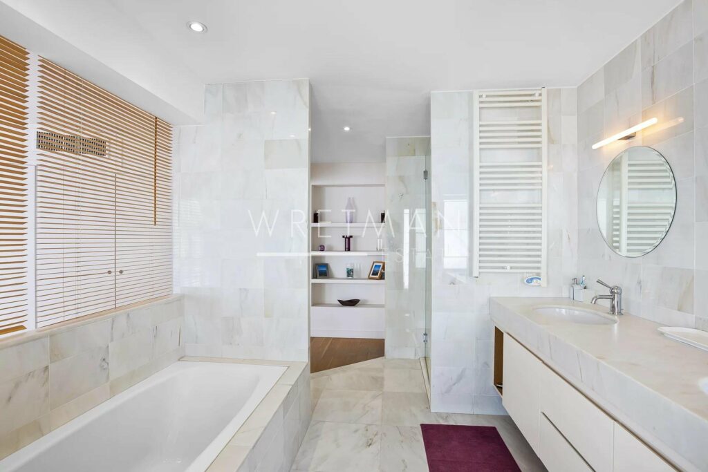 open bathroom with large bath tub and white marble walls