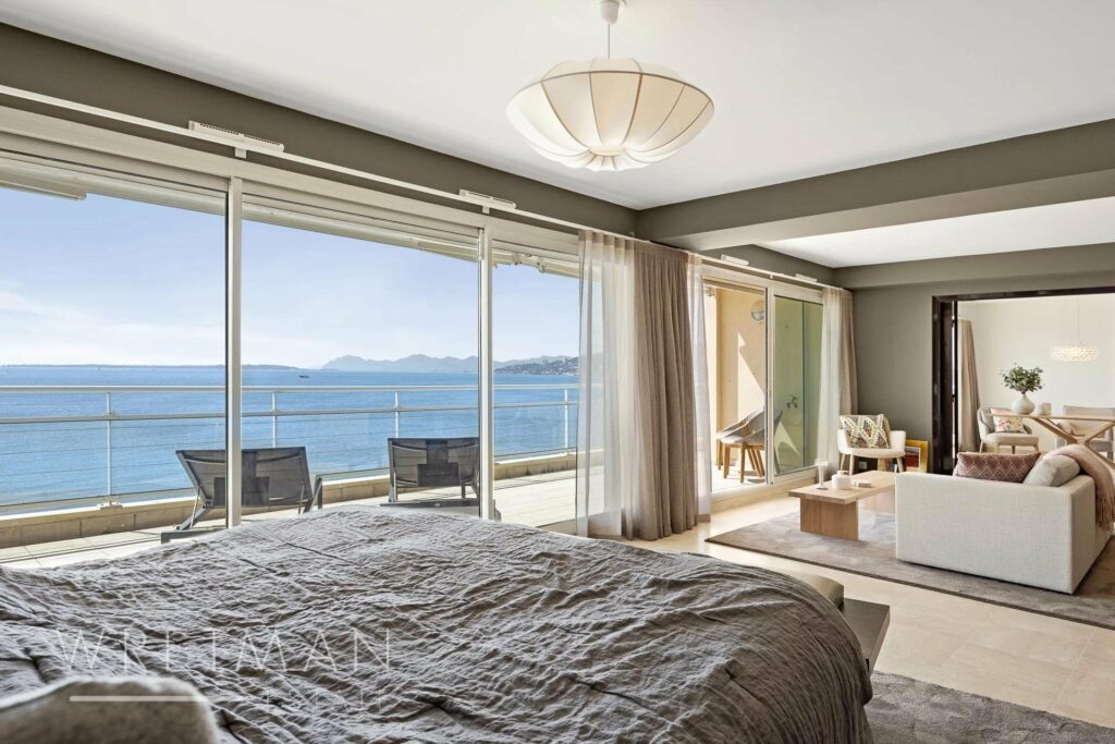 bedroom with queen size bed next to sliding glass doors with sea view terrace
