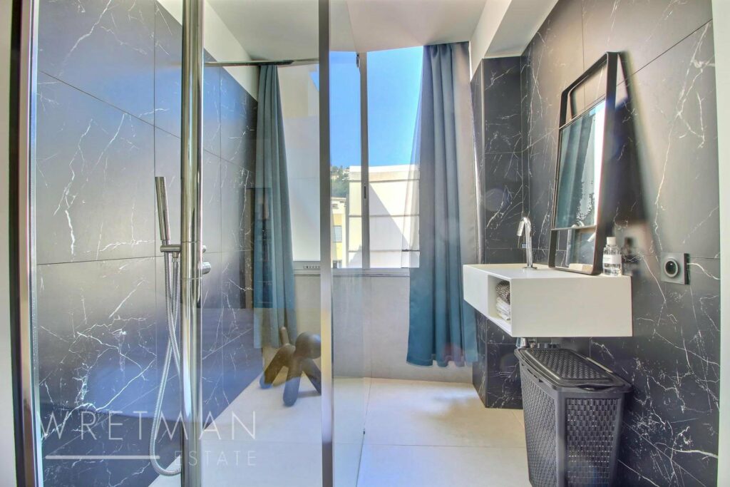 bathroom with large standing shower and white tile floors