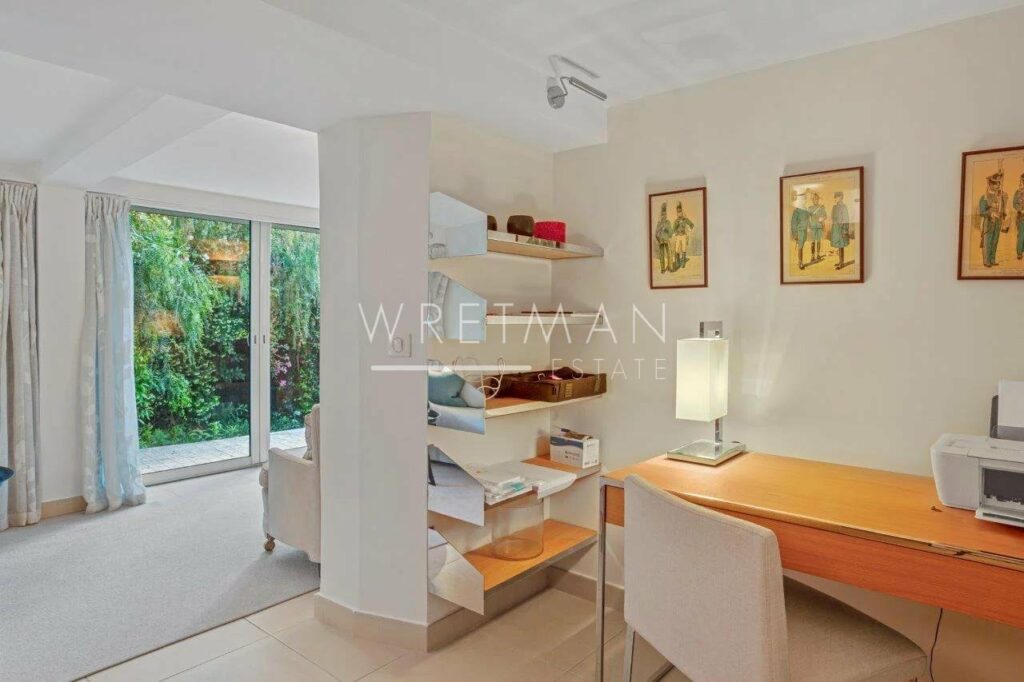office of villa in cannes with beige tile floors and wooden desk and white shelving