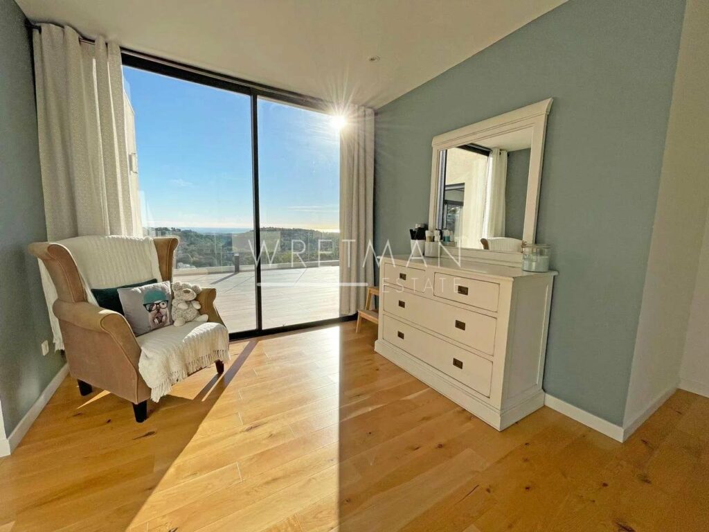 bedroom with wood floors and white dressing table and large mirror