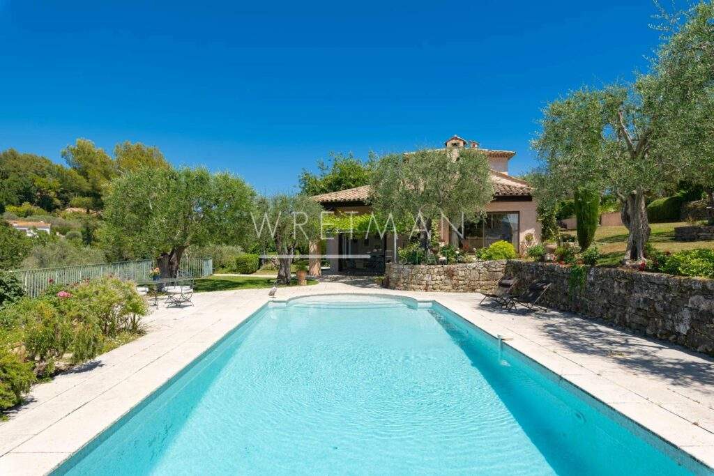 backyard of villa with large swimming pool and well manicured garden