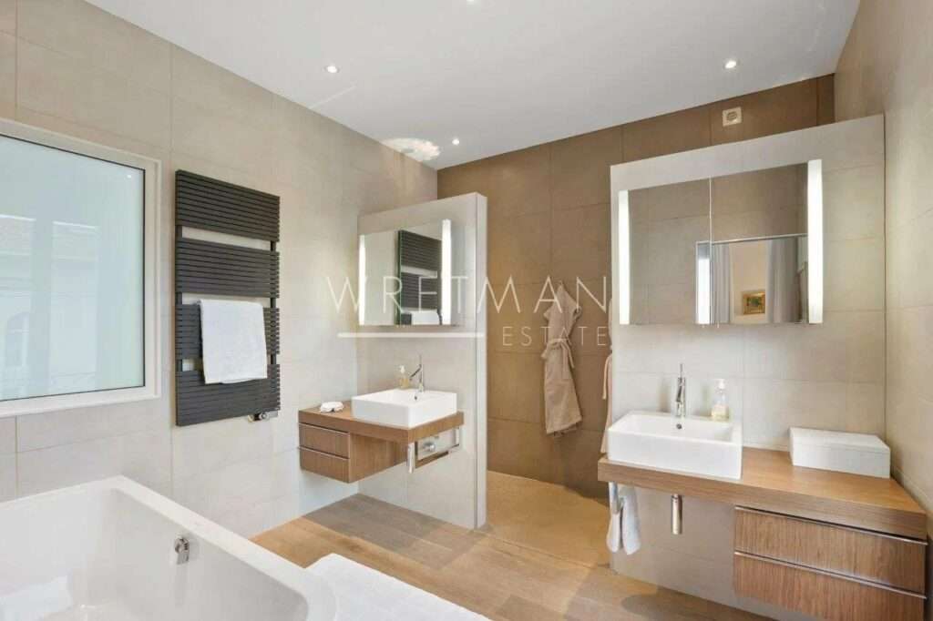 bathroom with brown tile floors and large bathtub
