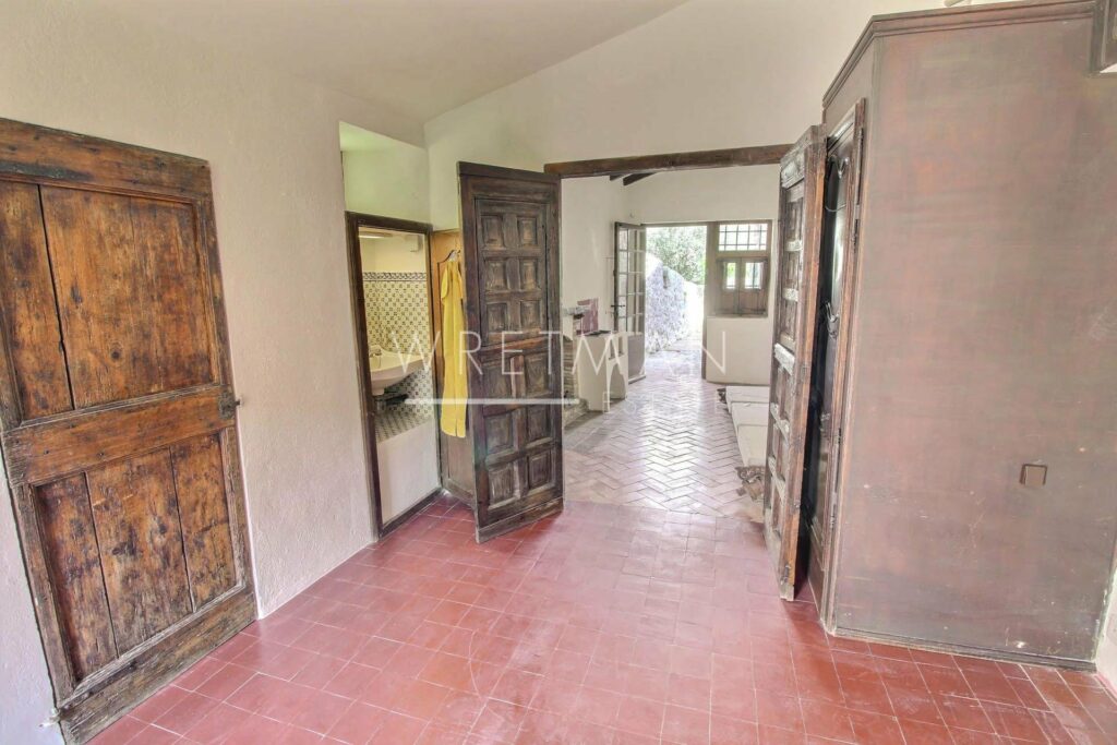 interior of provencal villa with red tile floors and large wooden doors