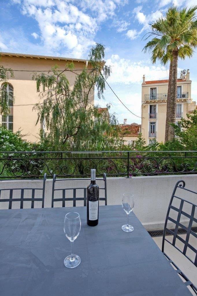 terrace with dark wooden table with wine bottle in center and two wine glasses
