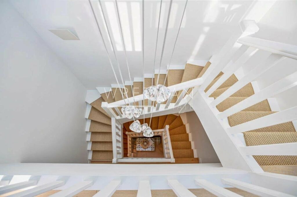all white staircase with woven rug