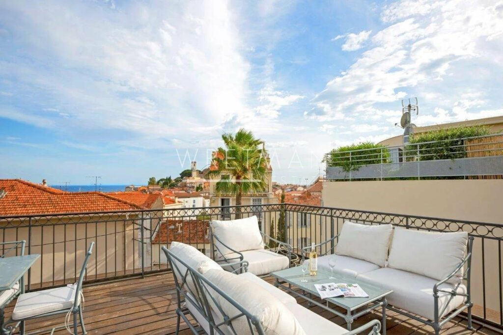 rooftop terrace with white patio furniture and sea view