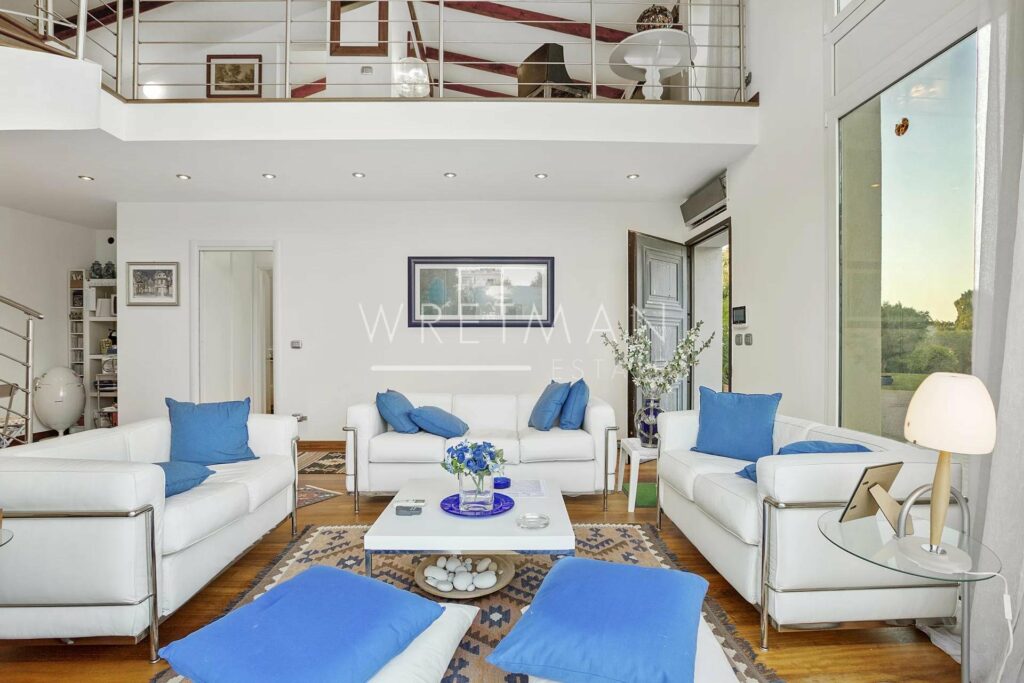 living room with white leather couch and bright blue accent pillows