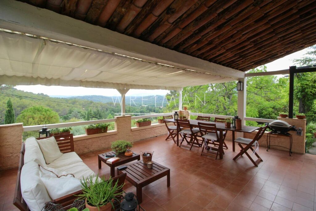 large terrace with terracotta tile floors and wooden furniture with view of mountains
