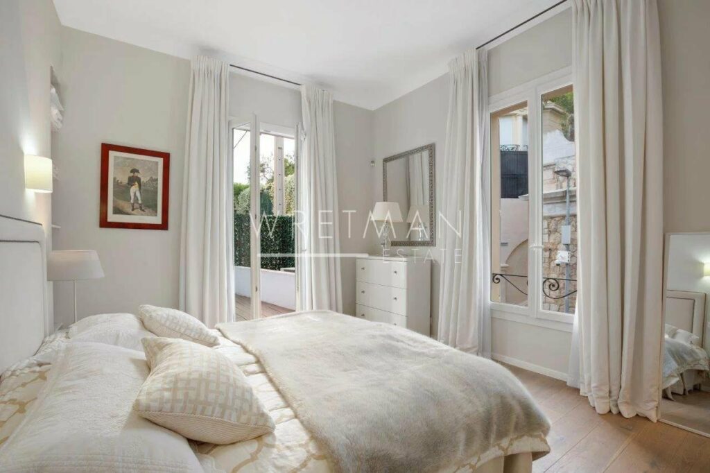 bedroom with queen size bed with two french doors to balcony