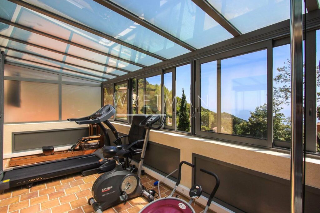 at home gym with large windows with garden view