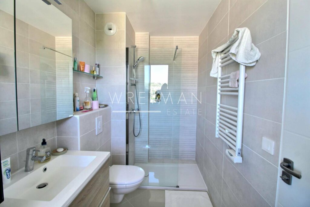 bathroom with standing shower and white tiling