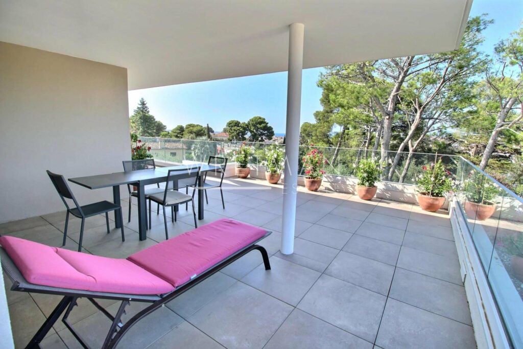 terrace with white tile floors and pink sun chair with view of garden