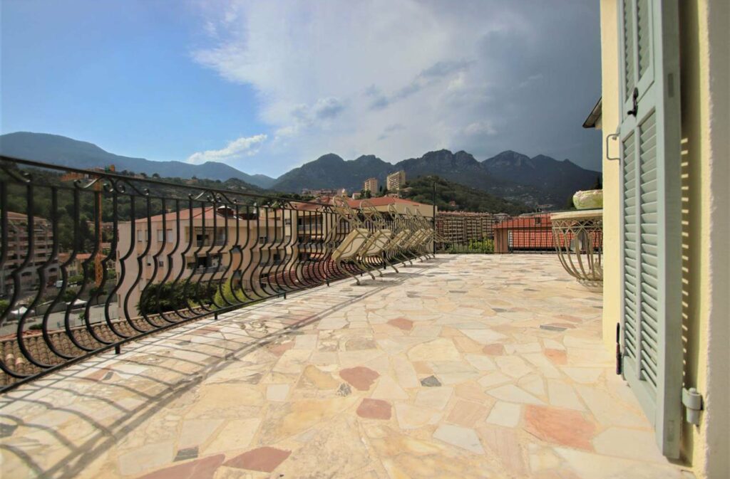 large terrace with view of surrounding mountains in menton