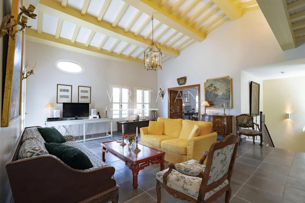 living room with yellow couch and high ceilings and exposed yellow beams