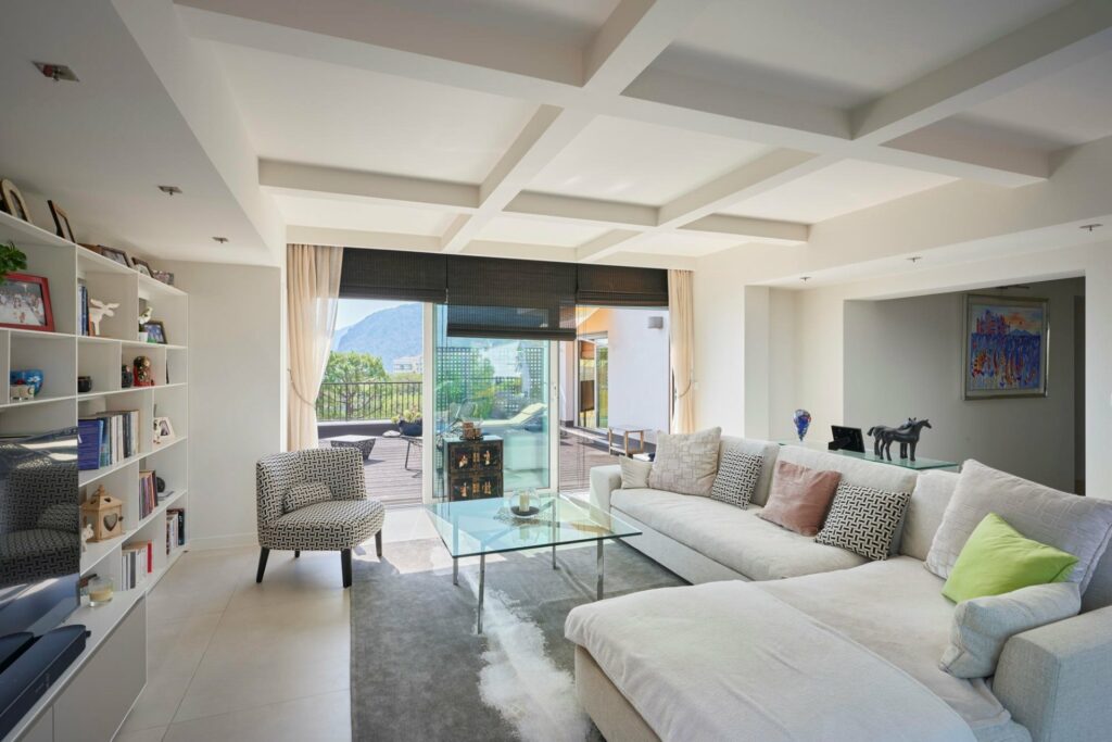 living room with white couch and sliding glass door to terrace with sea view