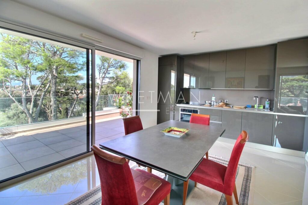 dining room with grey and red dining table and sliding glass door to terrace