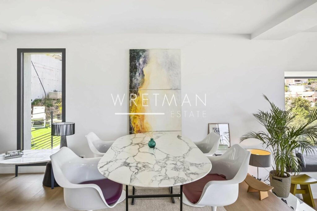 dining room with white marble table with modern art painting above