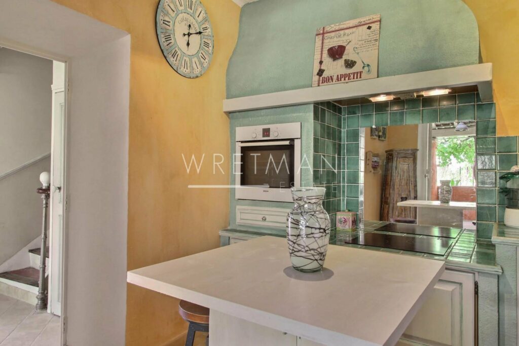 kitchen with white island in center and large clock hanging on wall