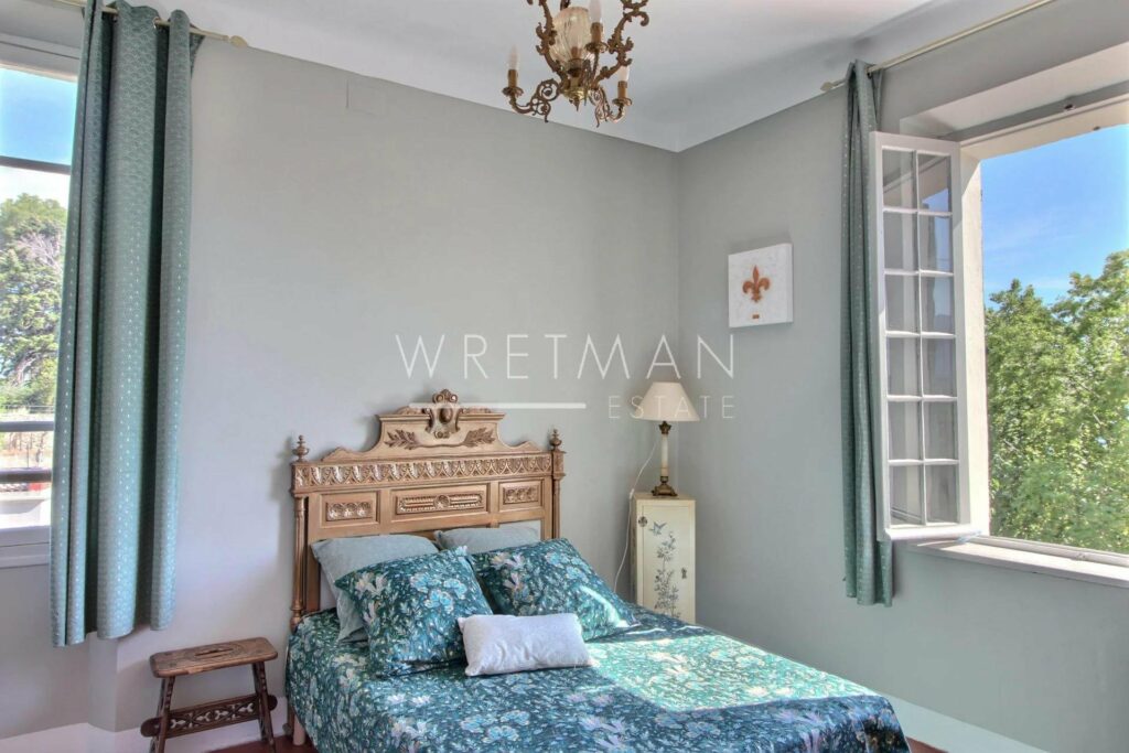bedroom with double bed with blue bedding and sage green walls