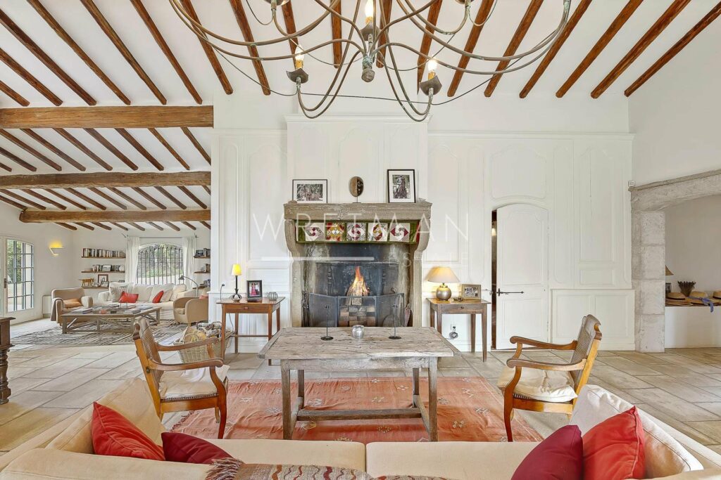 living room with wooden fireplace and high ceilings with exposed beams